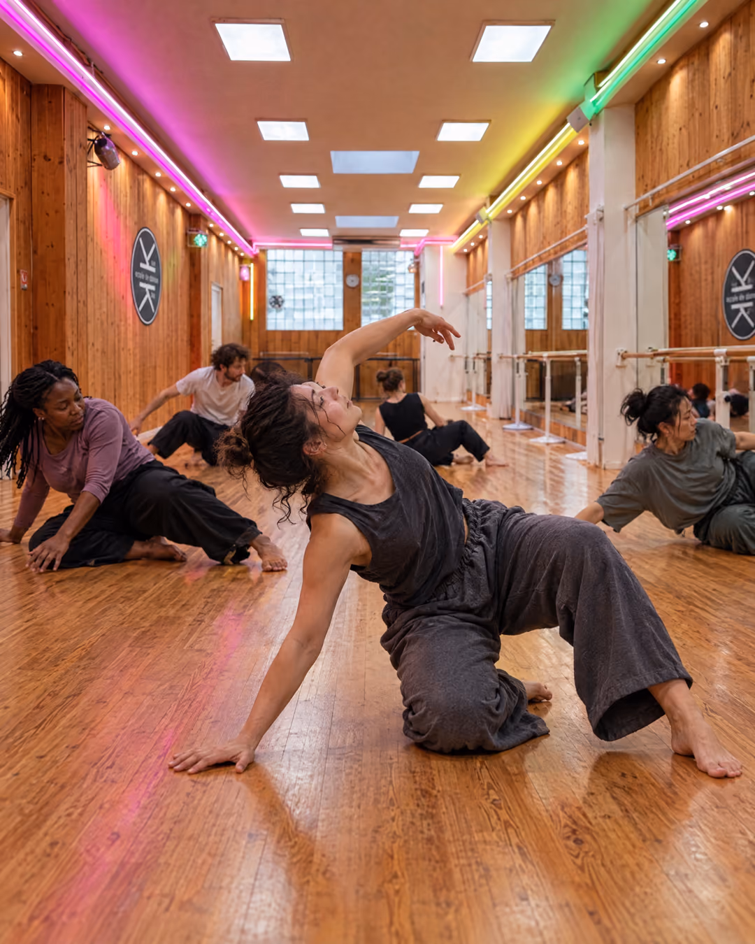 Contemporain : des adultes pieds nus glissent et roulent au sol, une danseuse se relève dans une grande courbe, salle 1 de Gambetta.